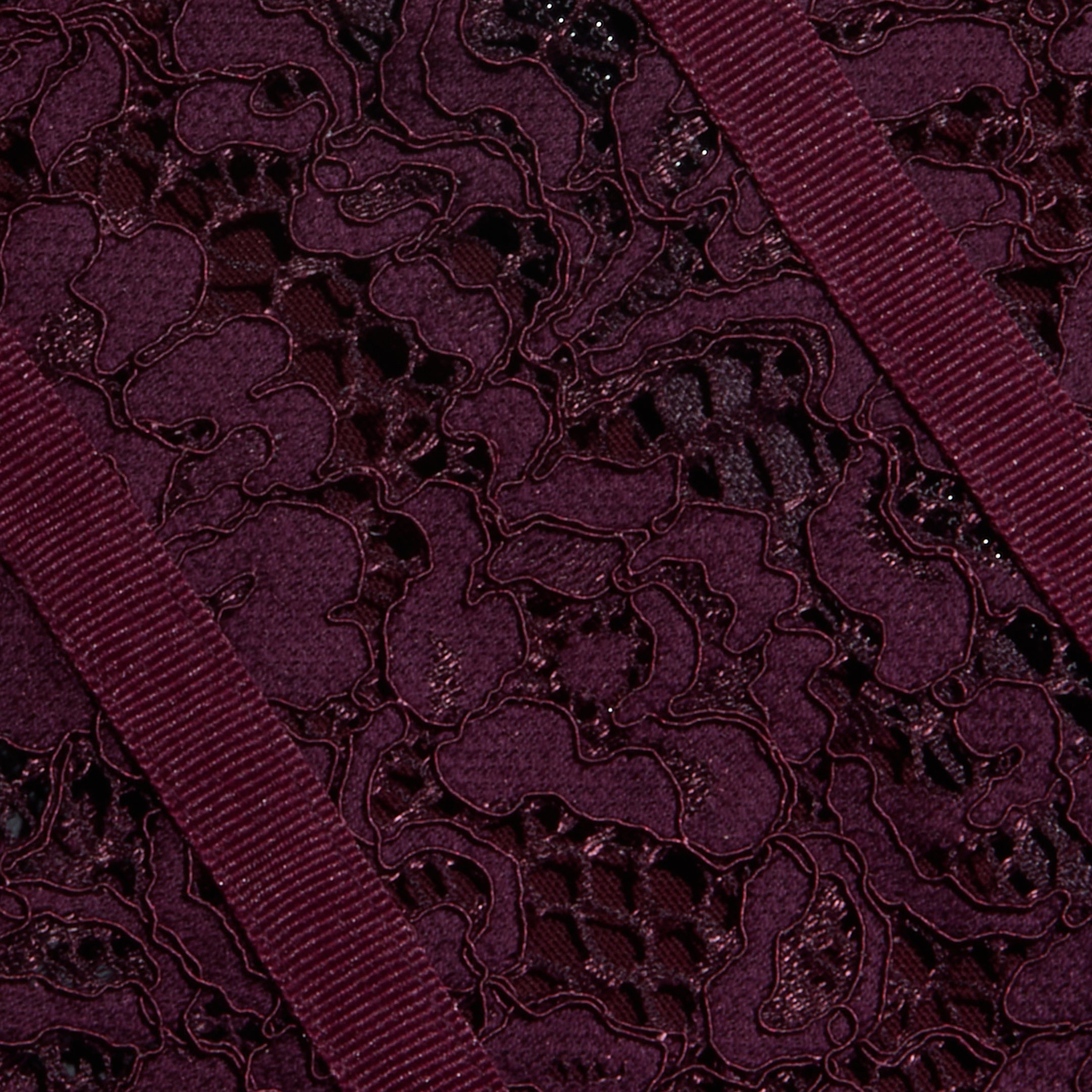 Close-up of the Jenny Lace Bustier in dark burgundy, featuring intricate floral lace and two textured ribbon stripes running diagonally across the design.