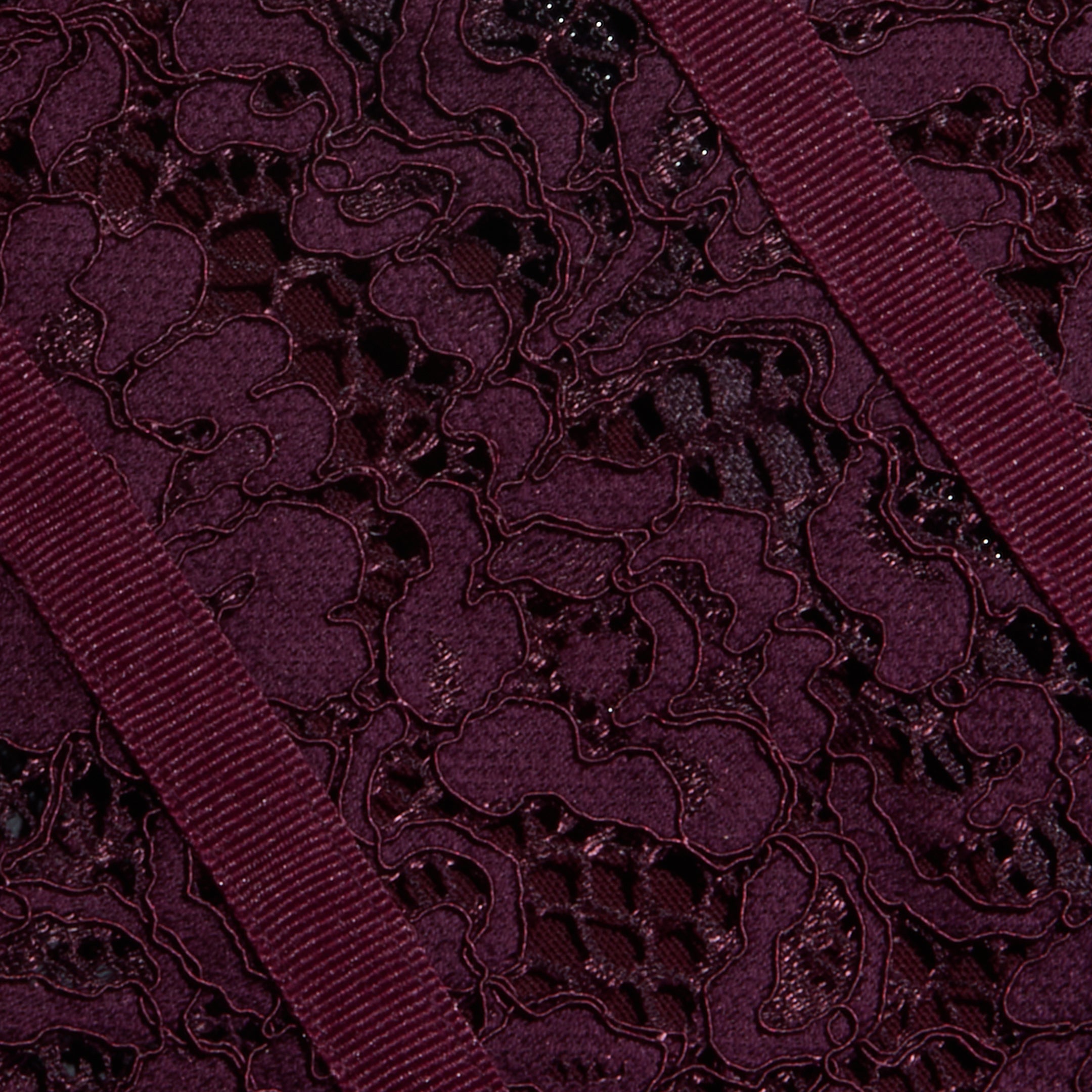 Close-up of the Jenny Lace Bustier in dark burgundy, featuring intricate floral lace and two textured ribbon stripes running diagonally across the design.