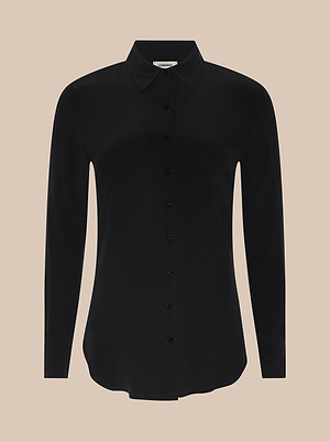 The Babette Silk Blouse is a black, long-sleeved crepe de chine button-up with a classic collar and relaxed fit, displayed on a plain beige background.