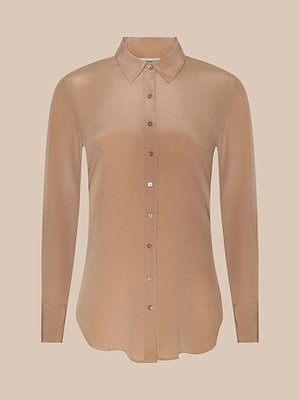 The Babette Silk Blouse is a long-sleeve, light brown crepe de chine top with a collar, button-up front, and relaxed fit, shown against a plain beige background.