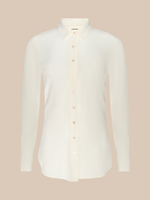 The Babette Silk Blouse is a classic, long-sleeve cream crepe de chine top with a pointed collar and relaxed fit, shown against a plain beige background.