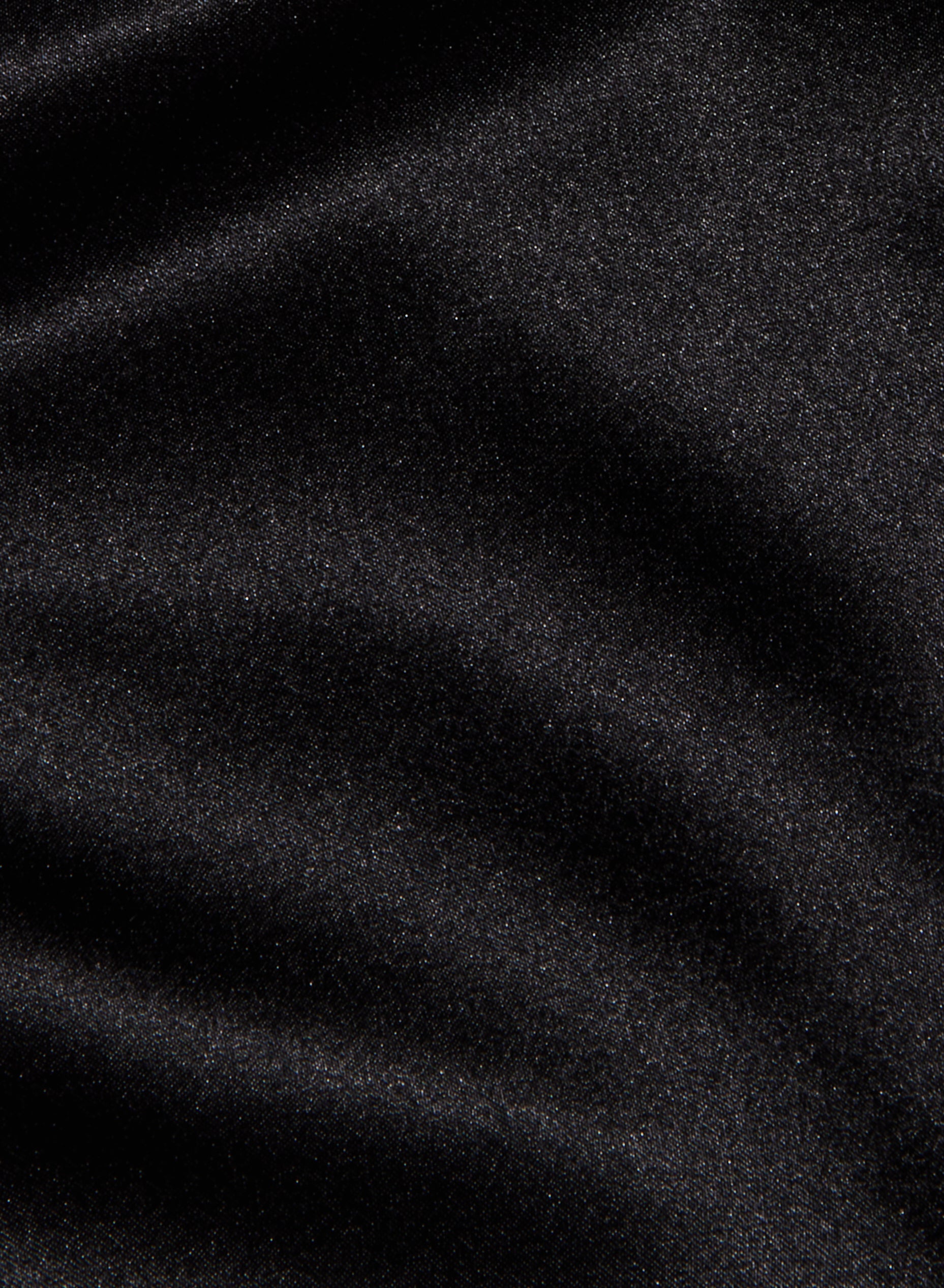 A close-up of the Evadne Silk Lace Camisole’s black silk fabric, featuring a soft, velvety texture with subtle highlights and gentle folds, finished with a slight sheen reminiscent of charmeuse.