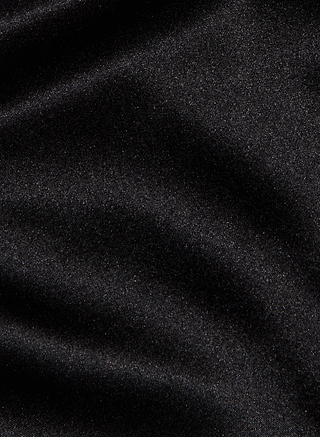 The Evadne Silk Lace Camisole features smooth, shiny black silk charmeuse fabric with gentle folds and a subtle, reflective sheen, exuding luxury and elegance.