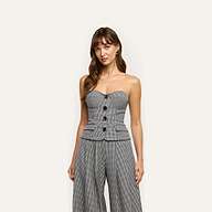 A woman wears a Genevieve Corset Top and matching wide-leg trousers in a black-and-white gingham pattern.