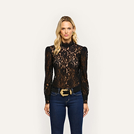 Woman wearing an Amarenthe Lace Blouse in black corded lace with a mockneck, tucked into dark wash jeans with a belt featuring an ornate gold buckle.