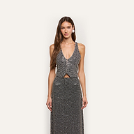 A woman wearing a black, hand-embellished Nixe Embellished Vest with sequins and crystals paired with a matching maxi skirt.