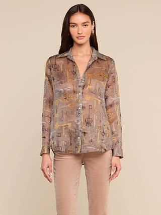 A woman stands facing forward, wearing the Nina Silk Blouse—a relaxed fit, long-sleeve button-up shirt in brown and beige tones—paired with light brown pants, against a plain beige background.