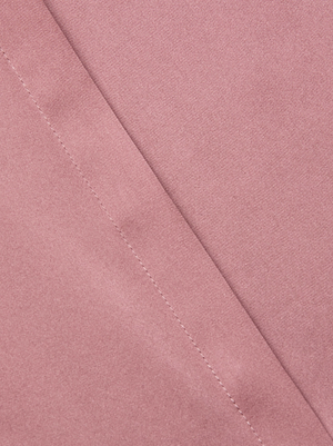 Close-up of the Bianca Silk Blouse by L'AGENCE in light pink charmeuse, featuring a diagonal seam with visible stitching. The fabric is soft and smooth, highlighting the blouse's luxurious texture and detailed craftsmanship.