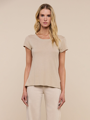A woman with long blonde hair faces forward, wearing the Cory Cotton Scoopneck Tee in taupe and light-colored pants, set against a plain beige background.