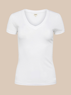 The Becca Cotton V-Neck Tee for women, made from 100 cotton, features a plain white short-sleeve design with no visible logos or designs and is displayed against a light beige background.