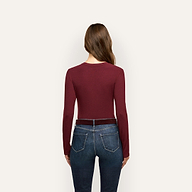 Back view of a person wearing a slim fit, burgundy Tess Long Sleeve Tee tucked into dark blue jeans with a belt.