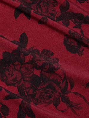 A close-up of burgundy floral print fabric with detailed flowers and leaves. The soft folds add depth—ideal for a fitted top like the L'AGENCE Ressi Fitted Tee.