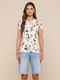 Wearing the Ressi Fitted Tee—a bestselling white T-shirt featuring a colorful print and crafted from slim-cut, stretch jersey knit—a woman stands facing forward against a plain, light background, paired with light blue knee-length denim shorts.