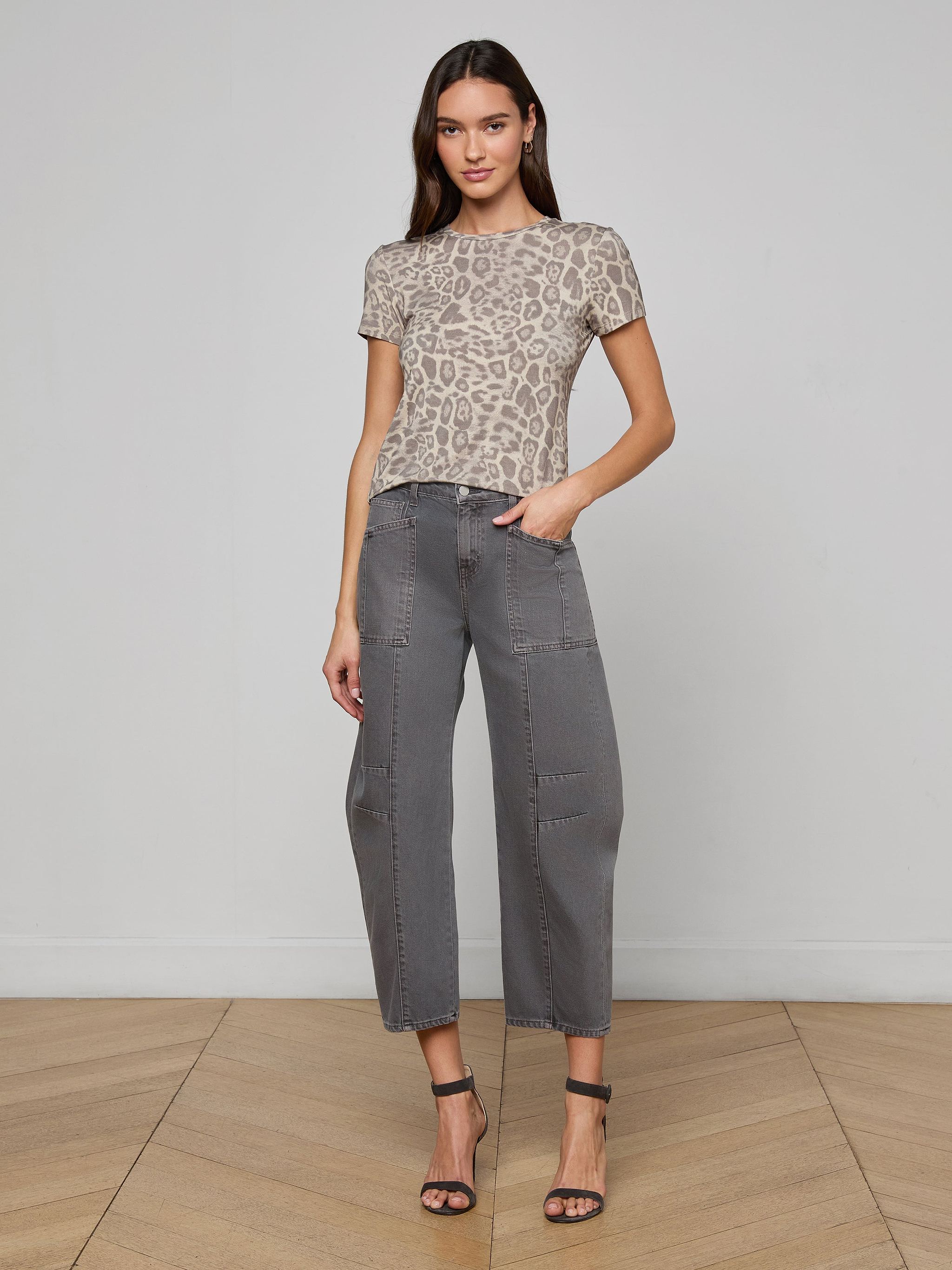 Woman wearing the Ressi Fitted Tee in gray leopard print, paired with gray cropped pants and black high-heeled sandals, standing against a plain white background.