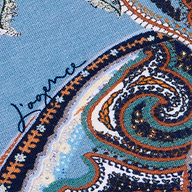 Close-up of the Ressi Fitted Tee in midnight blue paisley, featuring an intricate orange, green, and white pattern with the signature Jaeger written in dark ink on the left side.