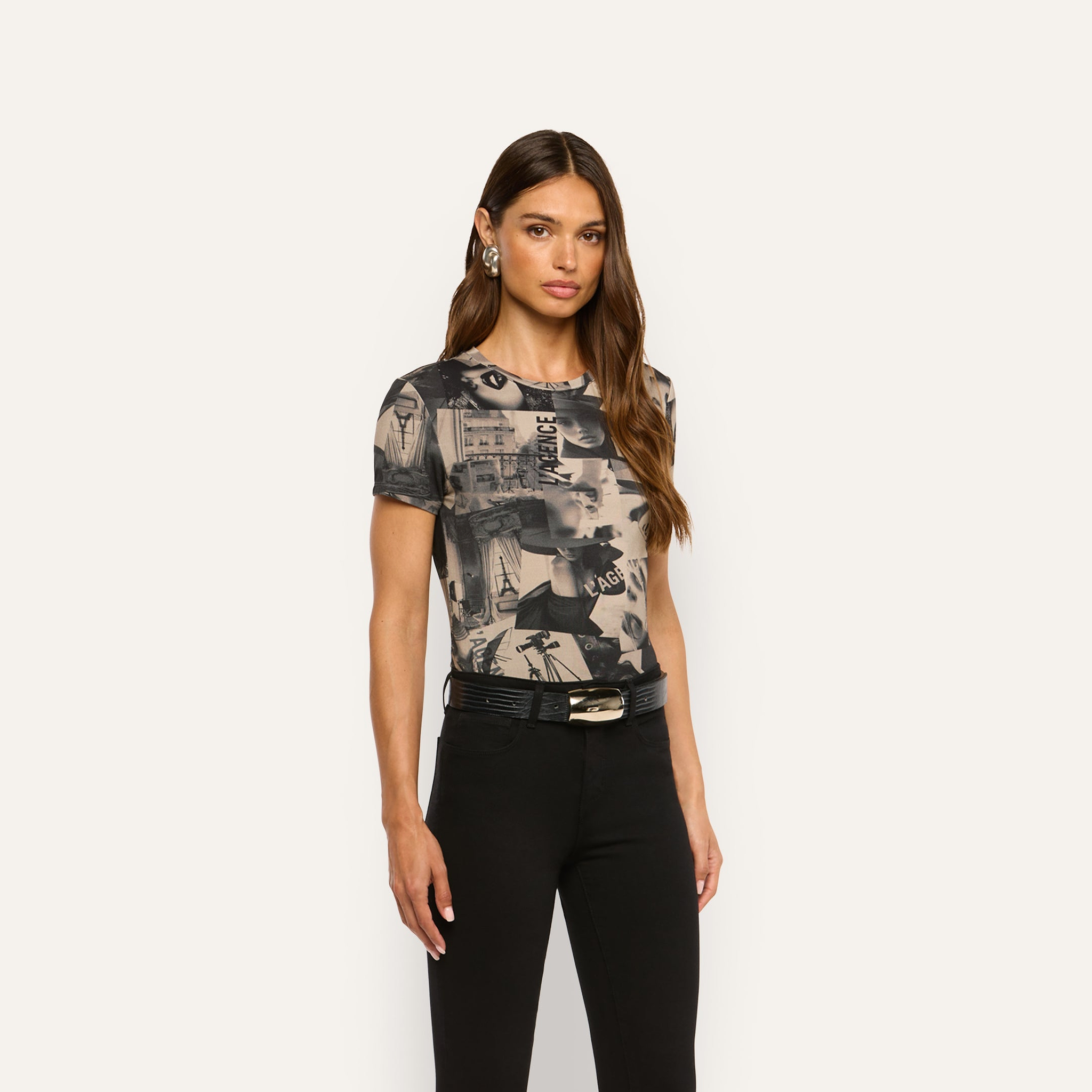 Model wearing a Ressi Fitted Tee featuring a magazine collage print, tucked into black pants with a black leather belt.
