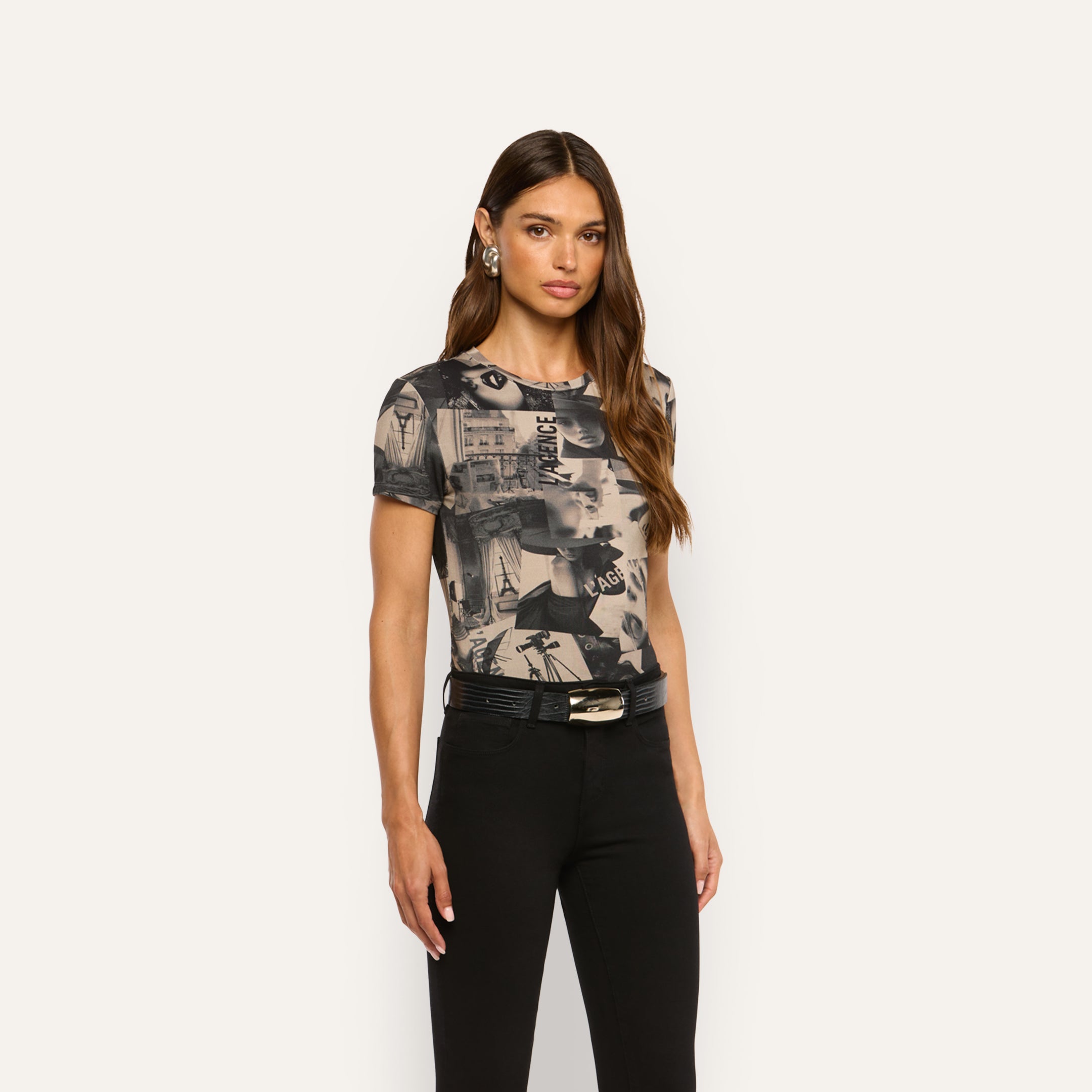 Model wearing a Ressi Fitted Tee featuring a magazine collage print, tucked into black pants with a black leather belt.