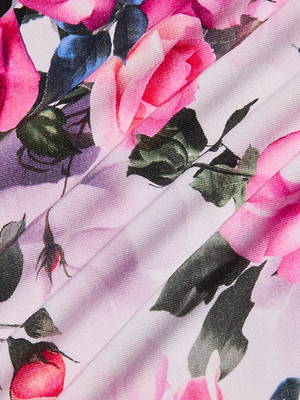 Close-up of pink and red roses with green leaves on light pink stretch jersey knit fabric, highlighting detailed floral patterns—ideal for the Ressi Fitted Tee with its charming pink rose print.