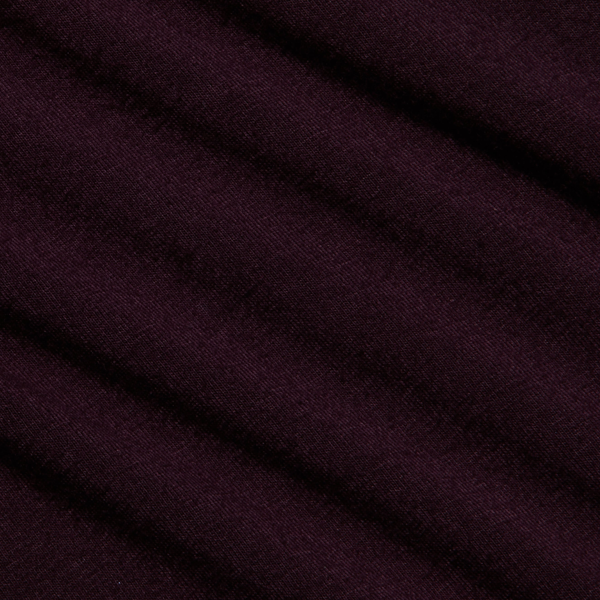 Close-up of the Lani Turtleneck’s deep purple fabric with a diagonal ribbed texture and soft, matte finish—ideal for Fall 2026. The material appears smooth, with gentle shadows accentuating the folds.