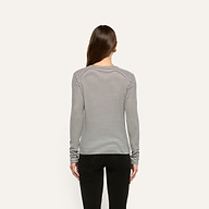 Back view of a person wearing a slim fit, black and white striped ribbed knit Tess Long Sleeve Tee tucked into black pants.