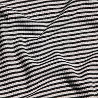 Close-up of the Tess Long Sleeve Tee featuring a black and white striped ribbed knit with gentle folds.