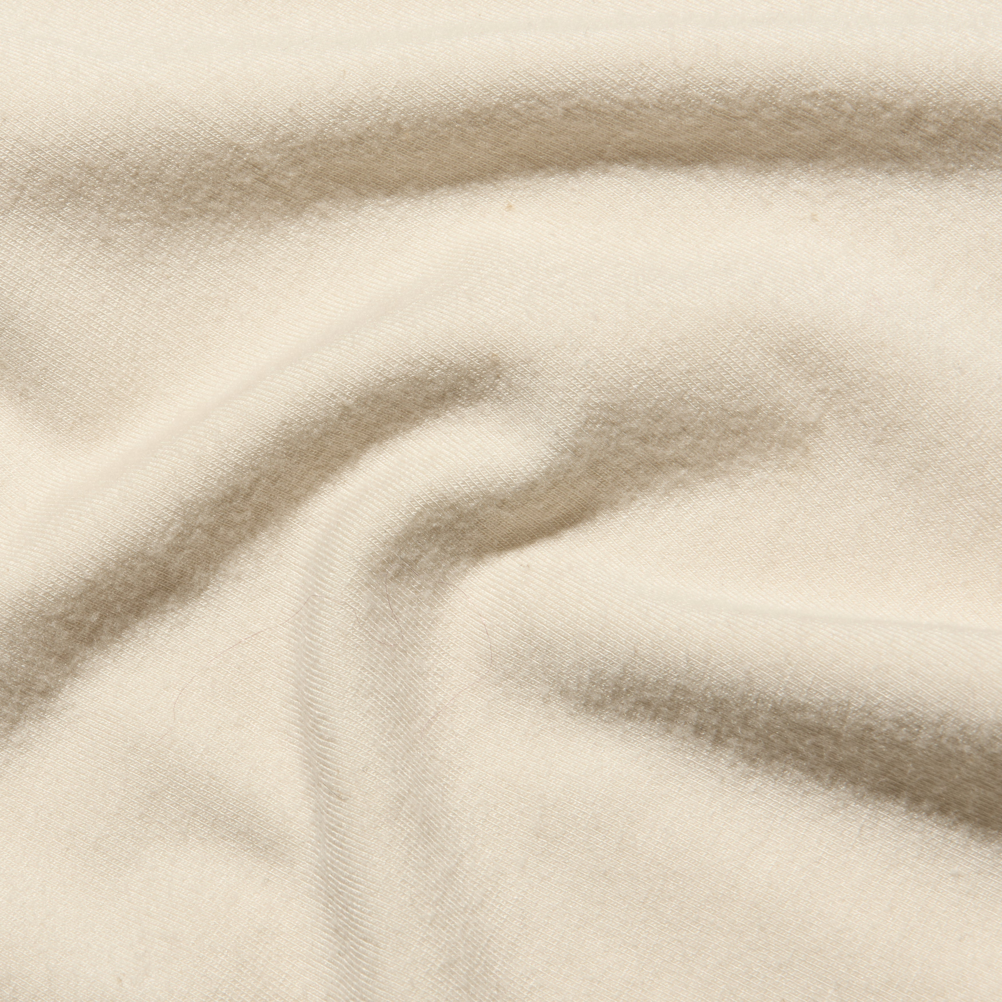 Close-up of a soft, cream-colored Ceci Sleeveless Turtleneck knit top with gentle folds.