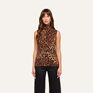 A woman with long brown hair wears the Ceci Sleeveless Turtleneck in a leopard print, paired with black pants. She stands against a plain light background, facing forward with a neutral expression.