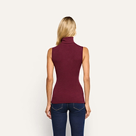 Back view of a person wearing a slim-fit, burgundy stretch rib knit Ceci Sleeveless Turtleneck and dark blue jeans.