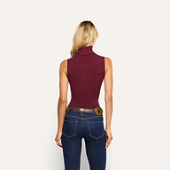 Back view of a person wearing a slim-fit, maroon stretch rib knit Ceci Sleeveless Turtleneck and dark blue jeans with a decorative western-style belt.
