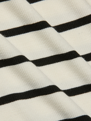 Close-up of the Lucille Striped Boatneck Top showcases its ribbed fabric with horizontal black and white stripes, creating a textured, slightly diagonal pattern for a timeless look.