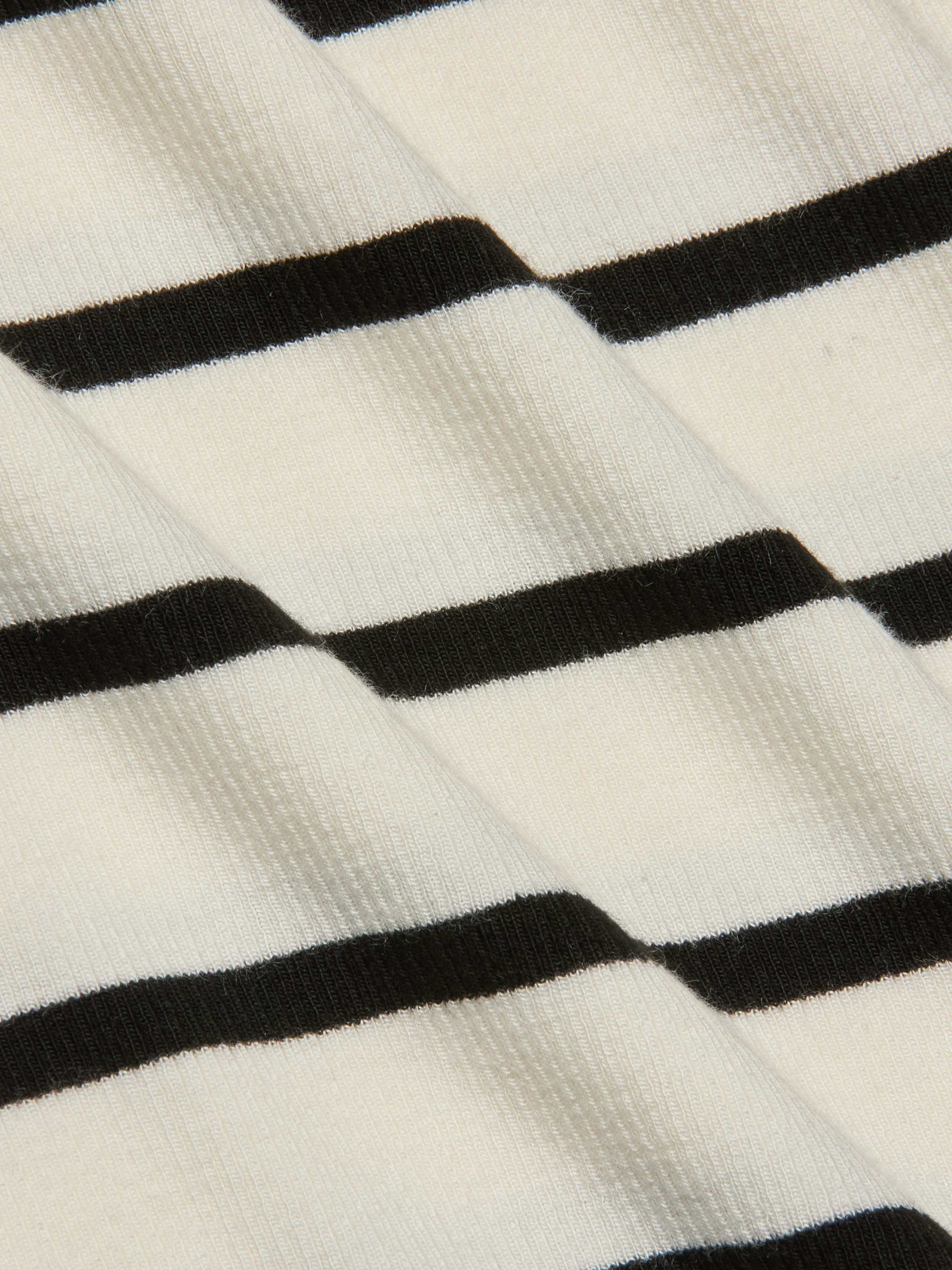 Close-up of the Lucille Striped Boatneck Top, highlighting its ribbed fabric with timeless black and white stripes arranged diagonally to showcase the texture and pattern.