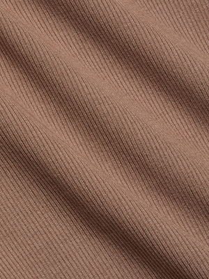 Close-up of the dusty rose ribbed fabric from the Nica Scoopneck Bodysuit, showcasing its stretch rib texture with diagonal folds and fine horizontal lines for a sculpted fit.