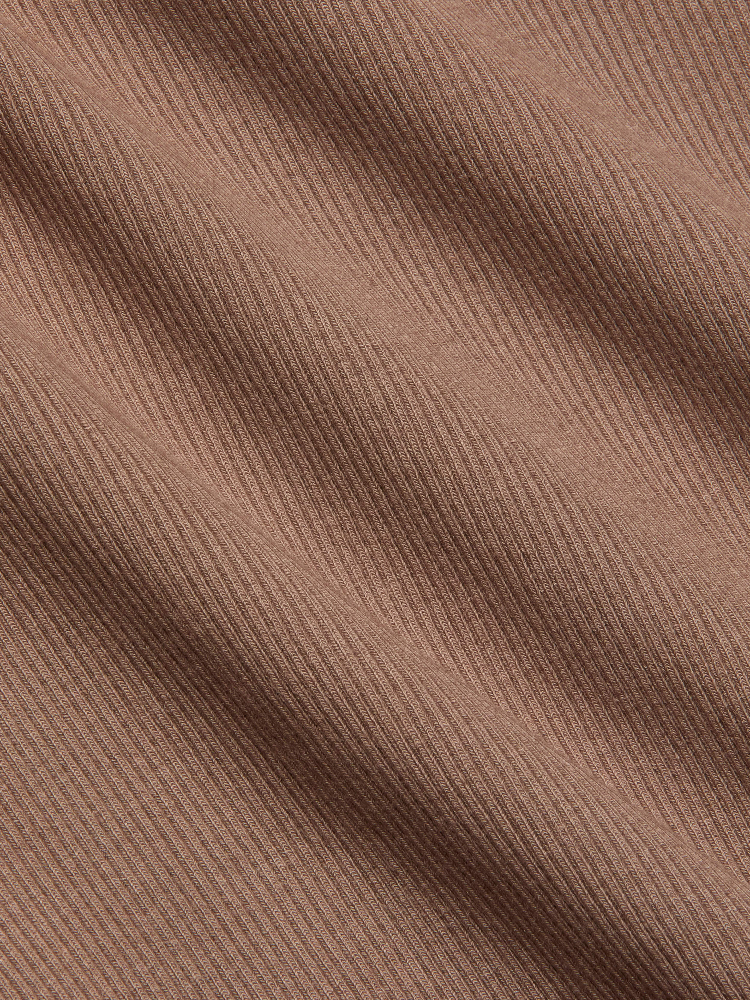 Close-up of the Nica Scoopneck Bodysuit in light brown stretch rib fabric, featuring diagonal textured lines that create a subtle pattern and soft shadows across the surface.