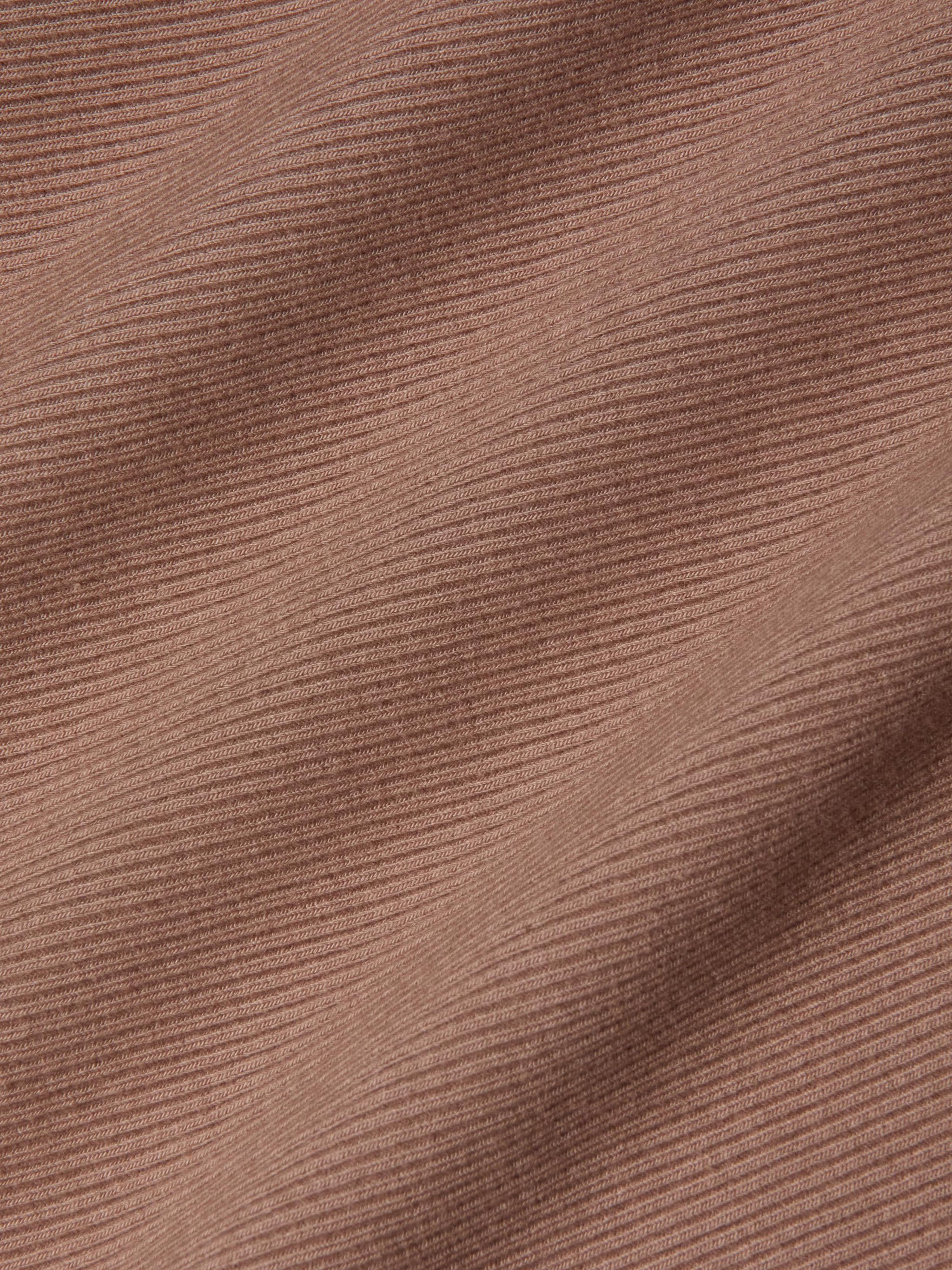Close-up of the Nica Scoopneck Bodysuit in a brown, high recovery stretch rib fabric featuring horizontal textured lines and soft shadows that enhance its depth and dimension.