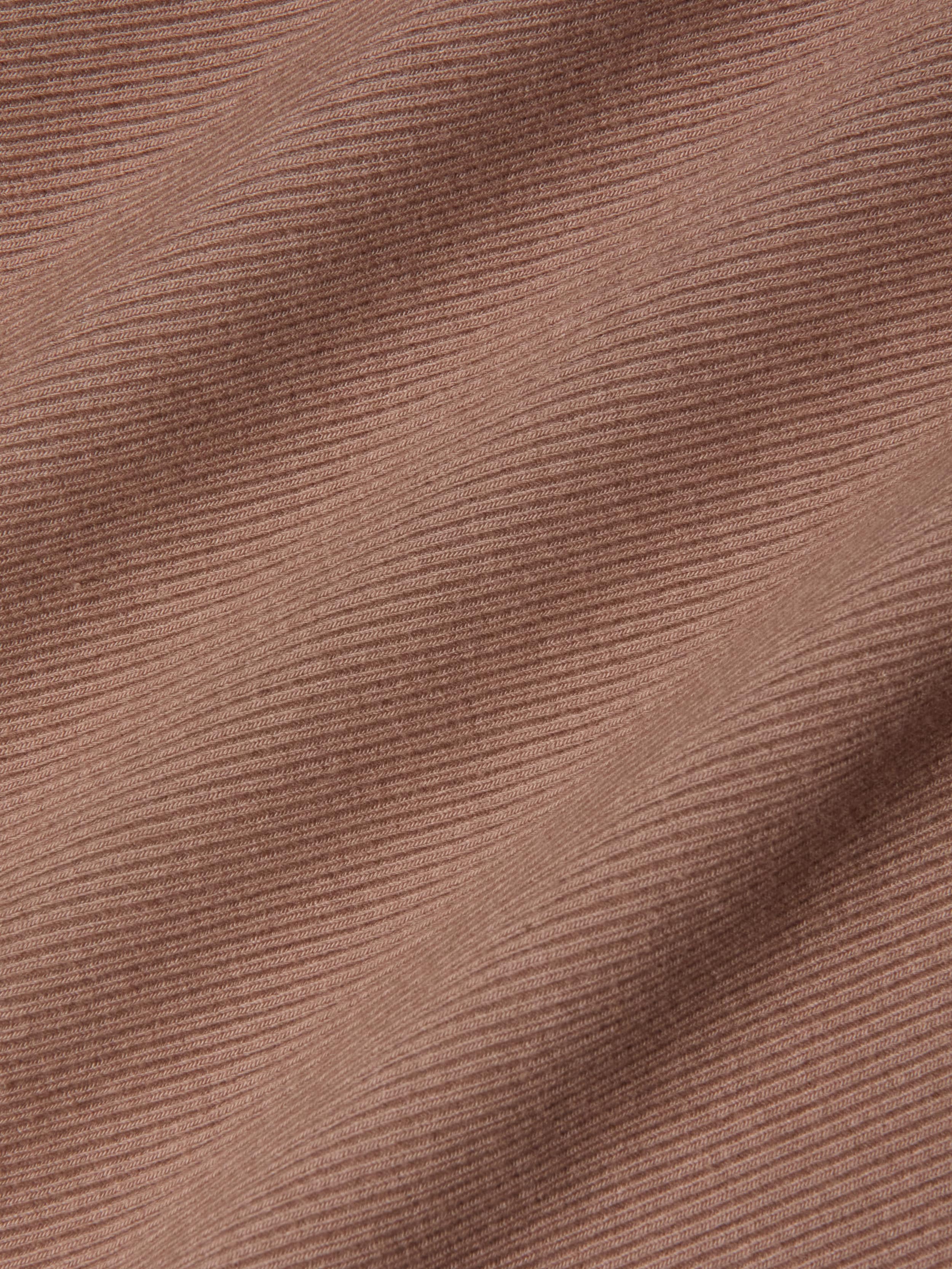 Close-up of the Nica Scoopneck Bodysuit in a brown, high recovery stretch rib fabric featuring horizontal textured lines and soft shadows that enhance its depth and dimension.