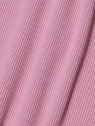 Gros plan sur un tissu côtelé rose avec des lignes texturées diagonales, créant une surface douce et à motifs. Le tissu appartient au body Nica Scoopneck et présente de légères ombres le long des crêtes sculptées de la coupe, là où il est légèrement étiré.