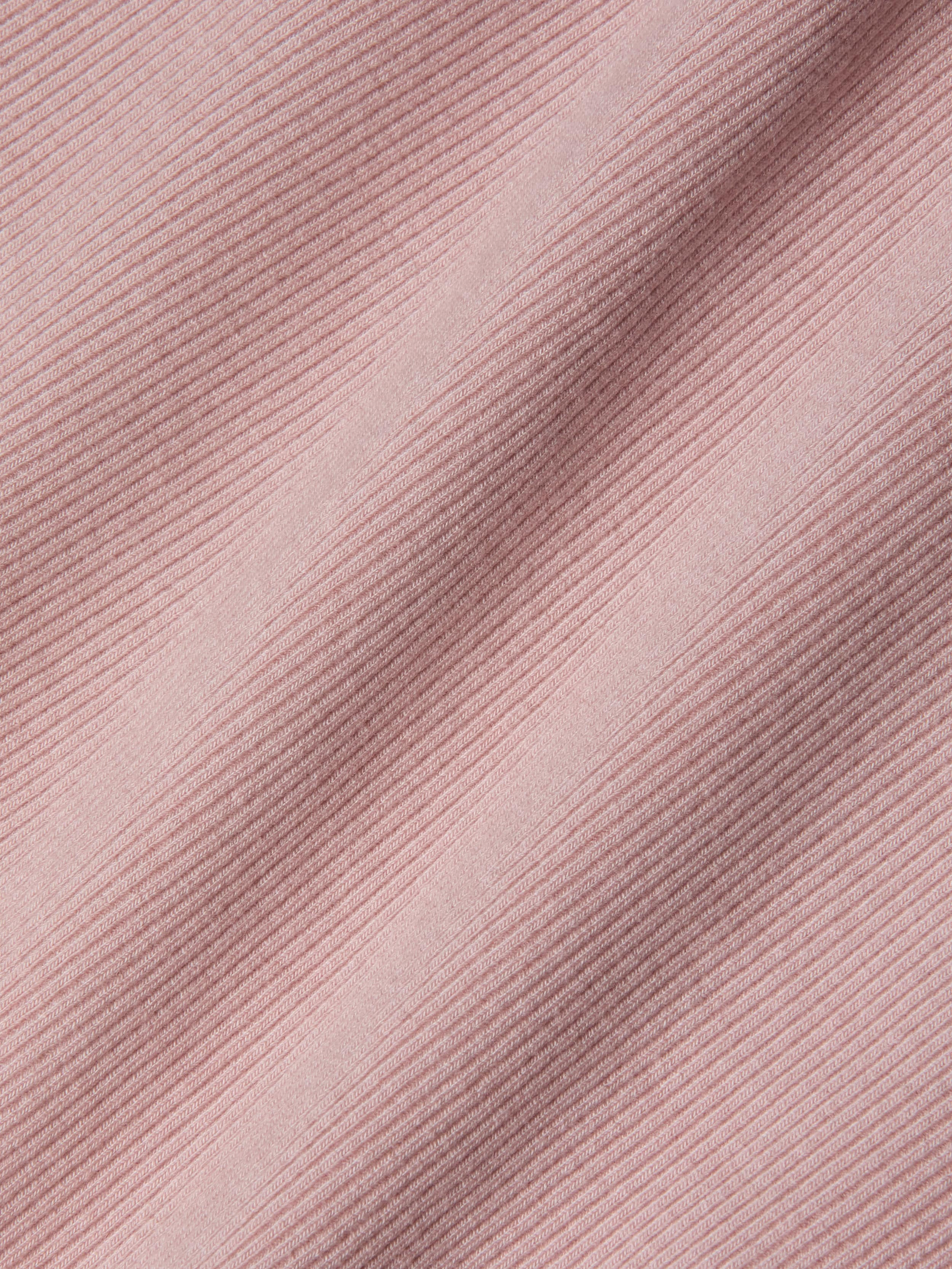 Close-up of pink ribbed fabric with diagonal textured lines and soft shadows, highlighting the detailed weave and pattern of this sculpted fit textile—perfect for the Nica Scoopneck Bodysuit.