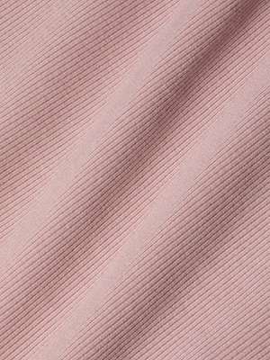 Close-up of light pink ribbed fabric from the Nica Scoopneck Bodysuit, showing diagonal, evenly spaced raised lines. The high recovery stretch rib sculpts the fit, while gentle folds create subtle shadows and depth on the surface.