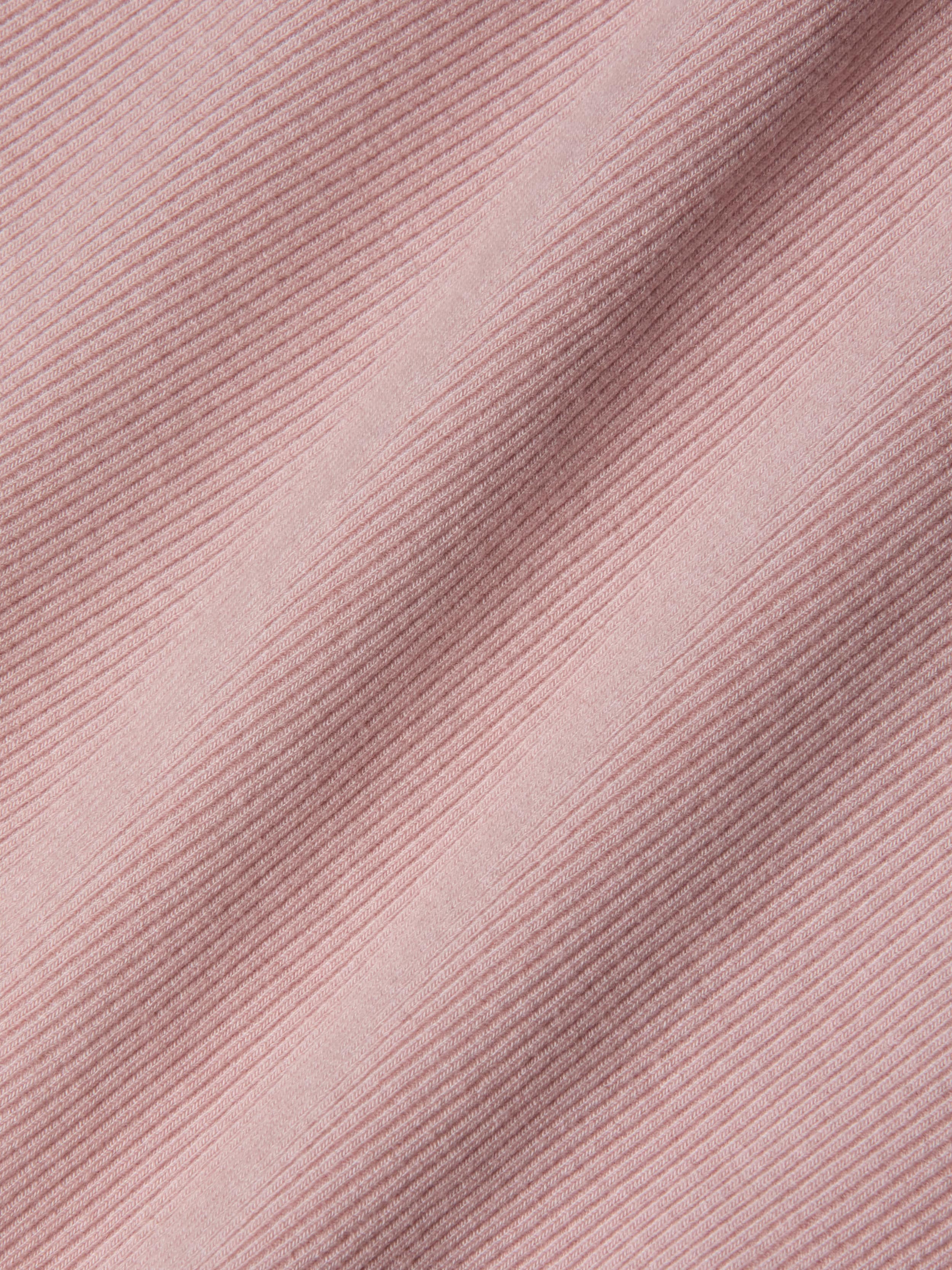 Close-up of pink ribbed fabric with diagonal textured lines and soft shadows, highlighting the detailed weave and pattern of this sculpted fit textile—perfect for the Nica Scoopneck Bodysuit.