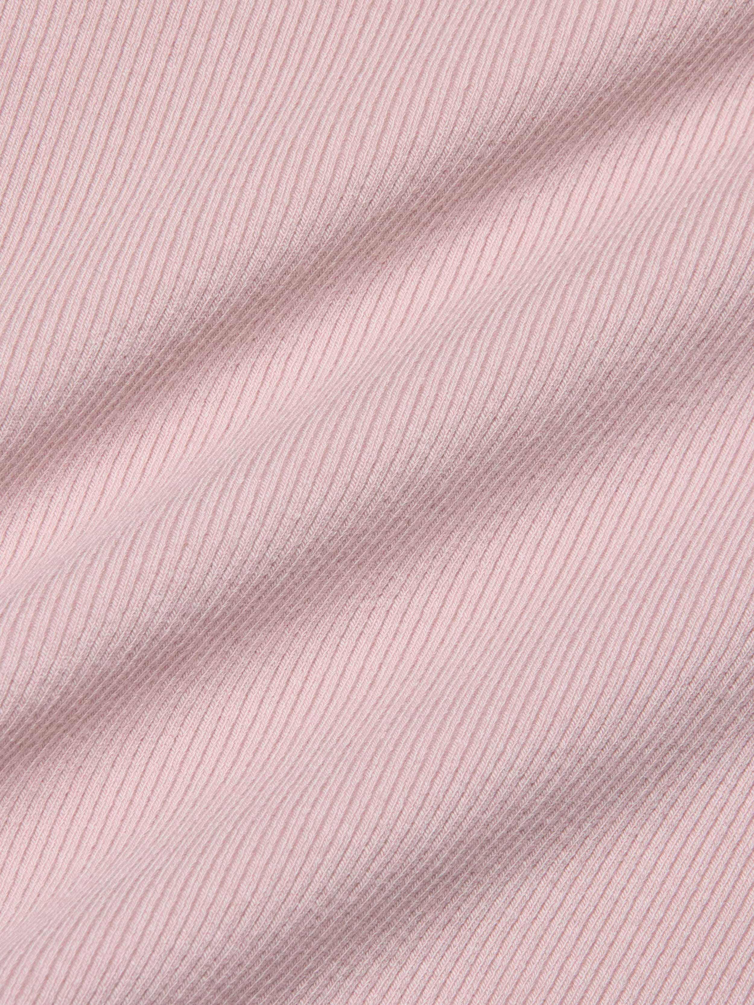 Close-up of the Nica Scoopneck Bodysuit in light pink, featuring high-stretch rib fabric with soft shadows emphasizing its texture and gentle folds.