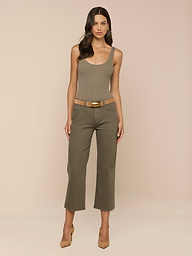 A woman stands facing forward, wearing the Nica Scoopneck Bodysuit in a sculpted fit, olive cropped pants with a tan belt, and tan high heels against a plain light background.