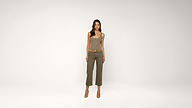 A woman stands against a plain white background, wearing a sleeveless ribbed top, belted olive green pants, and brown heels.