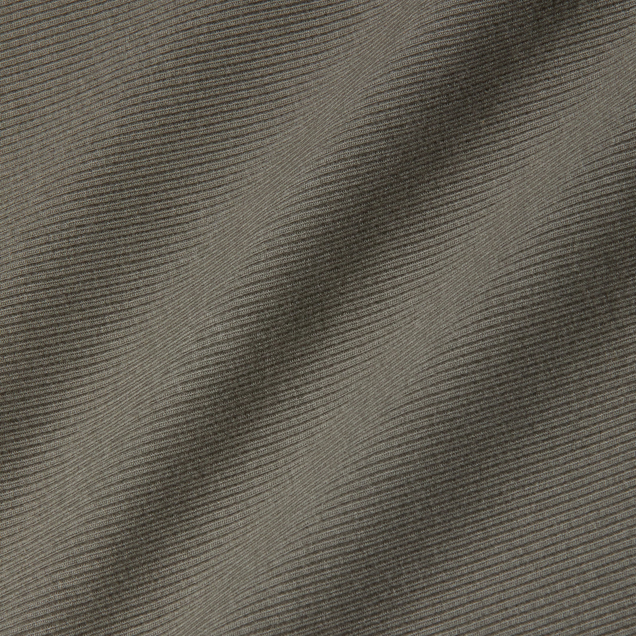 Close-up of grey ribbed fabric with diagonal ridges and subtle shadows highlighting the texture and folds, reminiscent of the sculpted fit featured in the Nica Scoopneck Bodysuit.