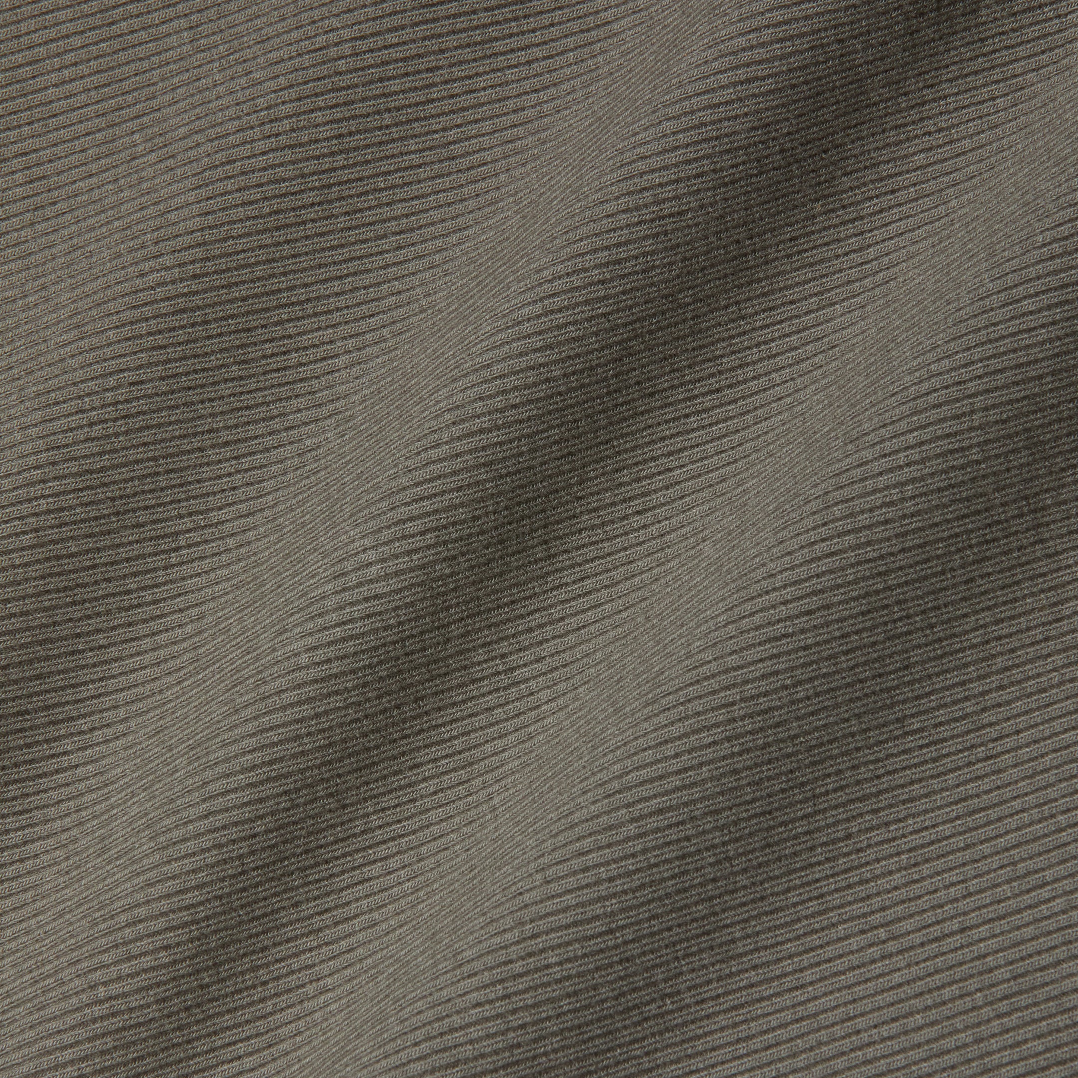 Close-up of grey ribbed fabric with diagonal ridges and subtle shadows highlighting the texture and folds, reminiscent of the sculpted fit featured in the Nica Scoopneck Bodysuit.