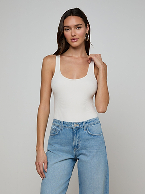 A woman poses confidently for a photo, wearing the sleek and stylish Nica Scoopneck Bodysuit.