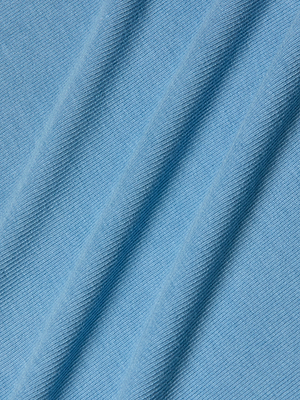 A close-up of light blue stretch rib fabric with diagonal folds creates soft shadows and lines, highlighting the gentle texture—ideal for the Adira Scoopneck Tank.
