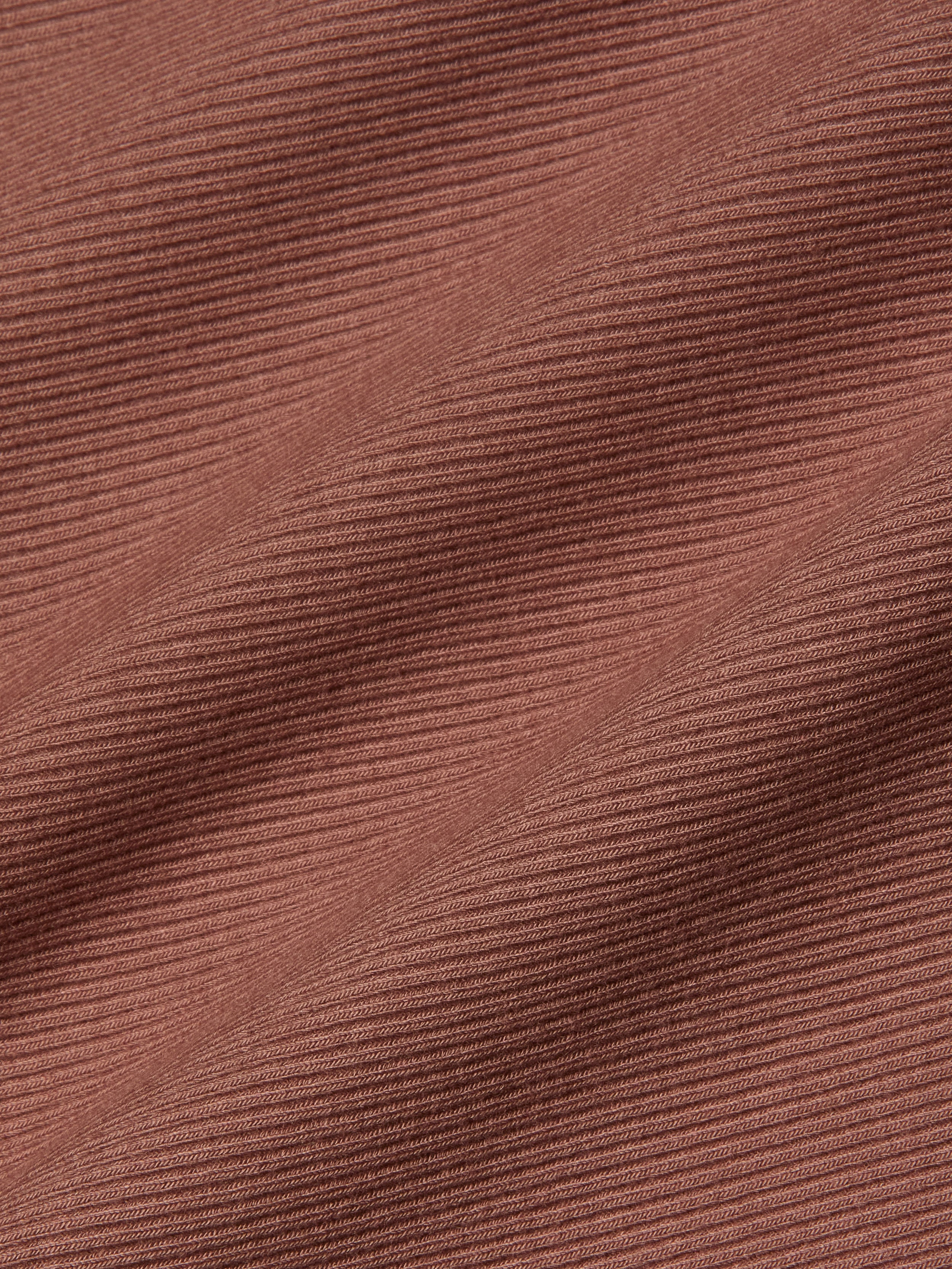 Close-up of the Adira Scoopneck Tank’s textured, ribbed fabric in a dusty rose hue, featuring subtle horizontal lines and gentle folds—ideal for this essential scoopneck style.