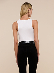 A person with long blonde hair is standing with their back to the camera, wearing the Adira Scoopneck Tank and blue jeans against a plain light background.