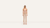 A stylish woman in sunglasses, a beige tank top, and matching flared pants with heels poses confidently against a plain white background.