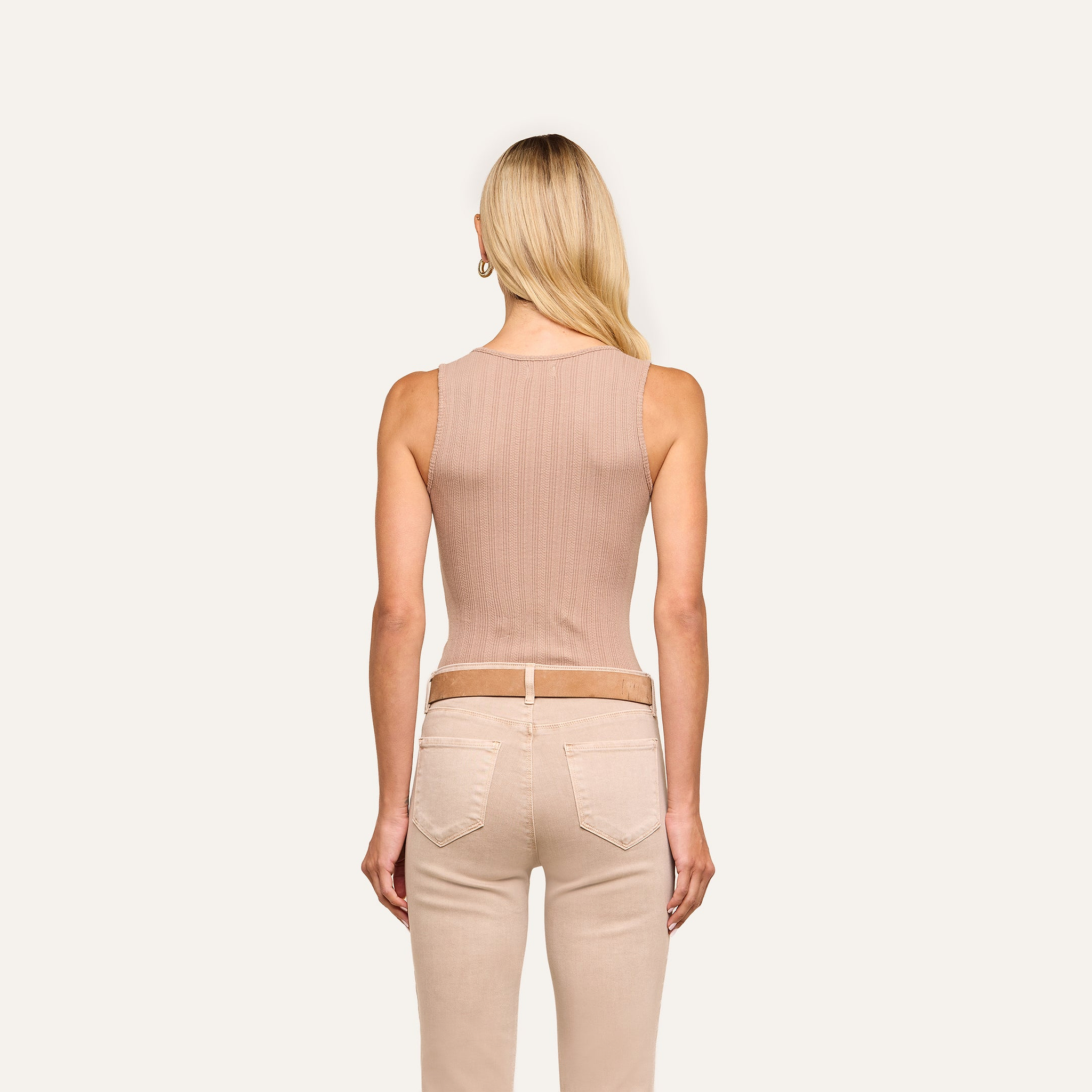 A woman with long blonde hair, seen from behind, is wearing the Adira Scoopneck Tank and light beige jeans against a plain, light-colored background.